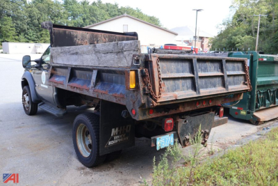 Dump truck bed and rear of a 2006 Ford F-550 dump truck showing rusted bed, taillights, and rear bumper with plastic license plate.