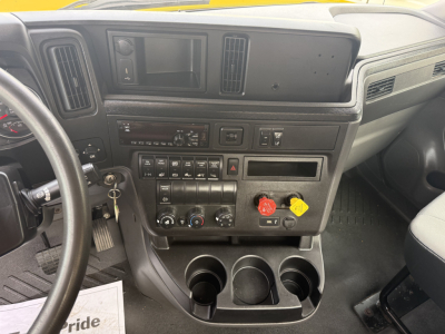 Dashboard and center console of a 2019 International LT cab showing switches, gauges, cup holders, and controls.