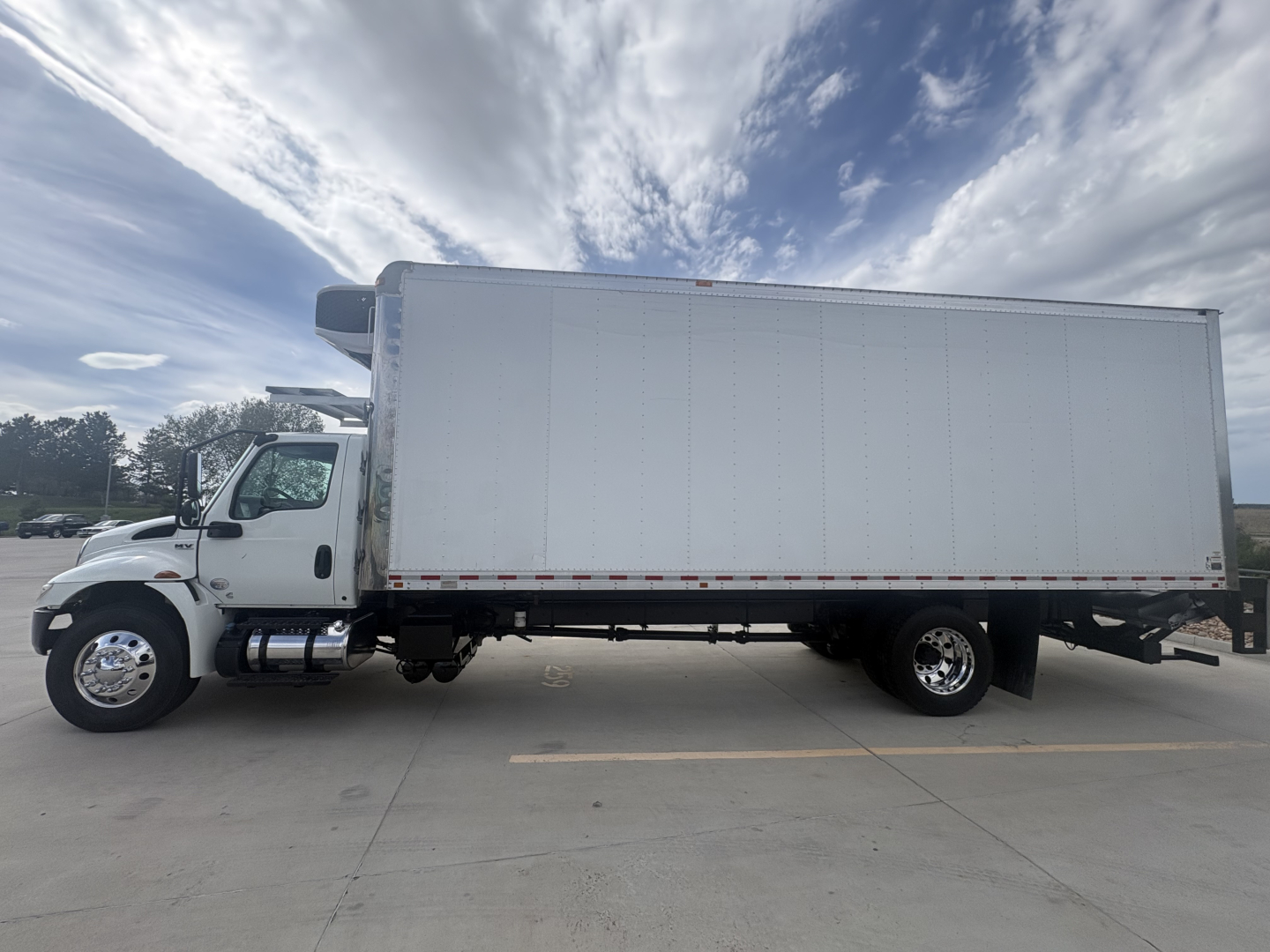 International MV607 refrigerated truck side view showing large box cargo area and cab with front chrome bumper.