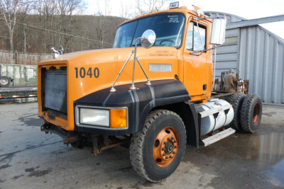 Orange 1998 Mack CH612 plow truck showing cab front with 1040 number, large mirrors, and dual rear wheels.