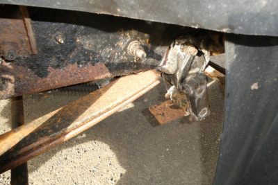 Trucks undercarriage detail showing rusted frame member and hitch area on a 1998 Mack CH612 plow truck.