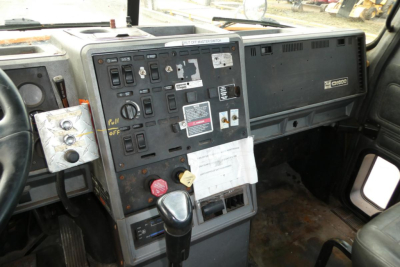 Cab interior of a Mack CH612 truck showing dashboard controls, switches, and shifter with labels and stickers.