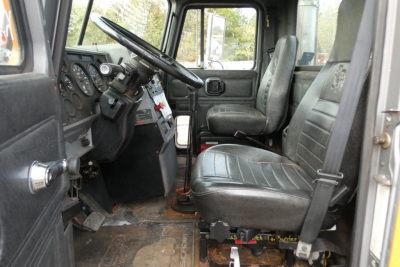 Truck interior cabin of a 1998 Mack CH612 plow truck showing driver seat and dashboard with steering wheel and gauges.