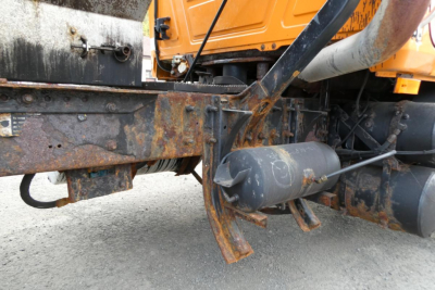 Mack CH612 plow truck undercarriage showing rusted frame, hydraulic tank, and exposed drivetrain components.