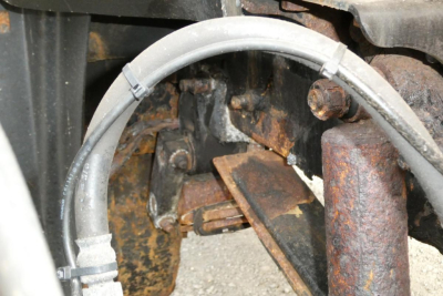 Mack CH612 truck component view showing rusted chassis and hydraulic line in close-up.