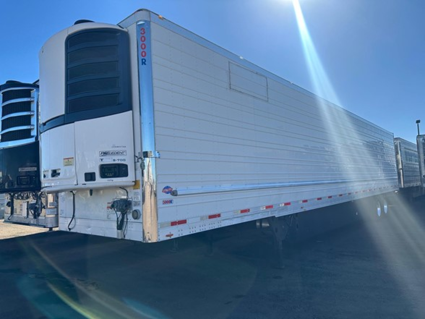Trailer side of a 2019 Utility 3000R refrigerated trailer showing vertical logo and side panels.