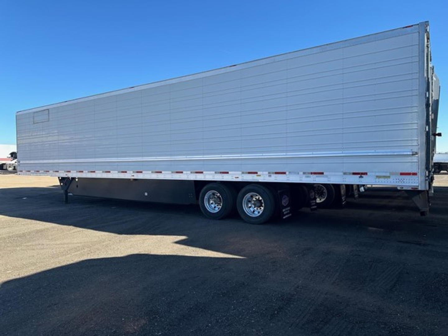 Utility 3000R trailer side view showing tandem axles and aluminum refrigerated trailer.