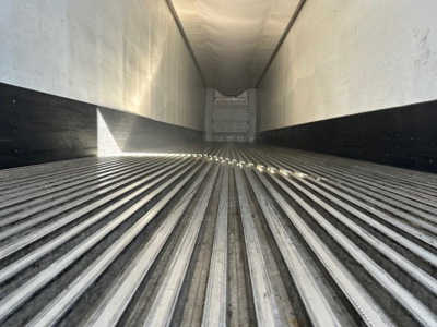 Interior of a refrigerated trailer trailer floor with ribbed steel and rear bulkhead, viewed from the front opening.