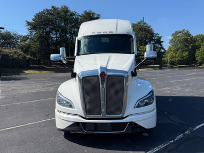Kenworth T680 front view showing large black grille, silver emblem, and dual mirrors.