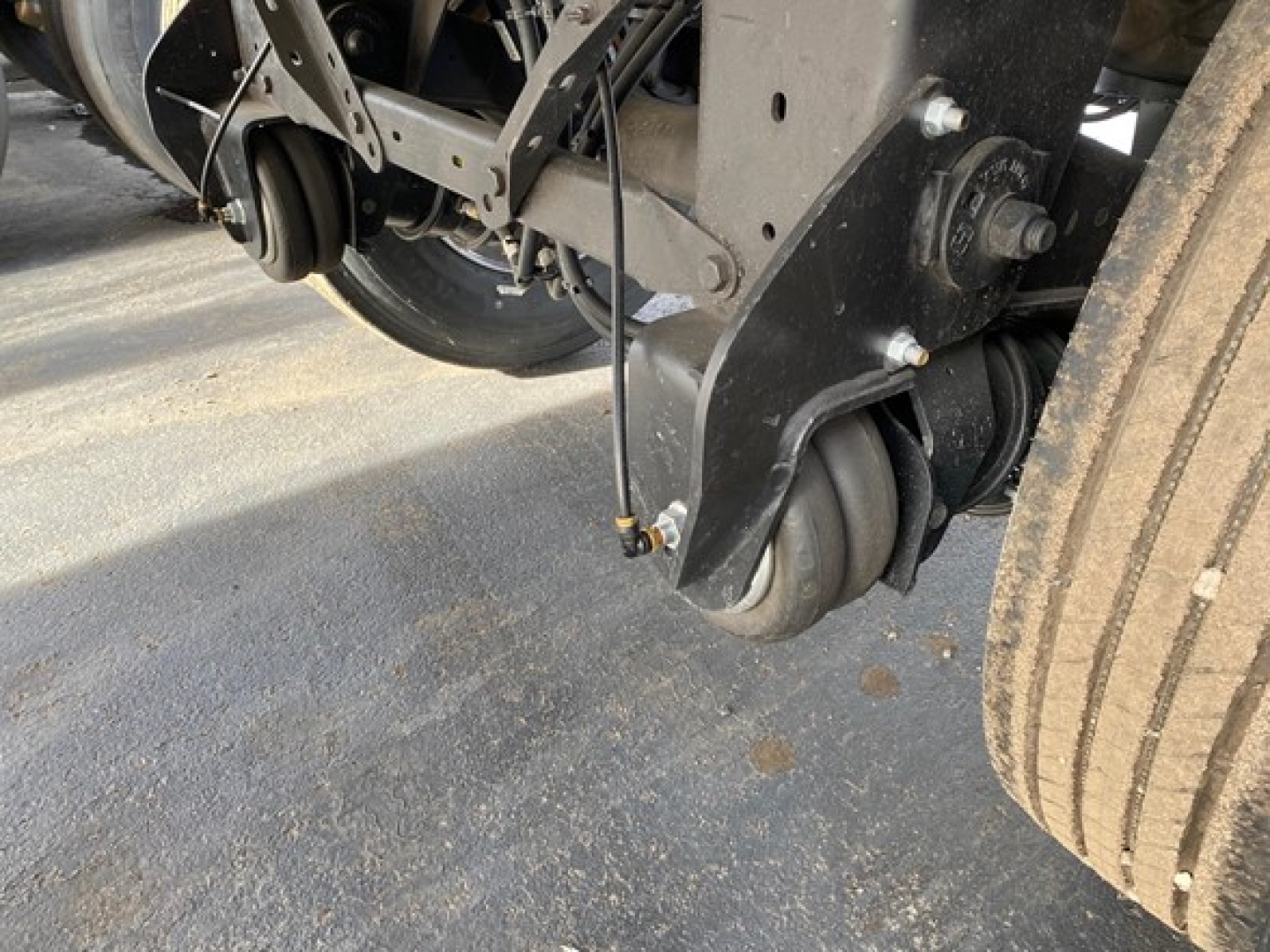 Trailer undercarriage showing wheels and suspension components with a visible tire and axle assembly.