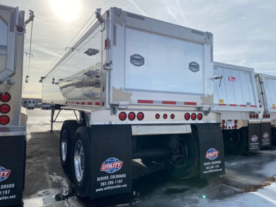 Dump trailer in a Mac light weight line showing dual rear axles and MAC logo on silver tailgate.