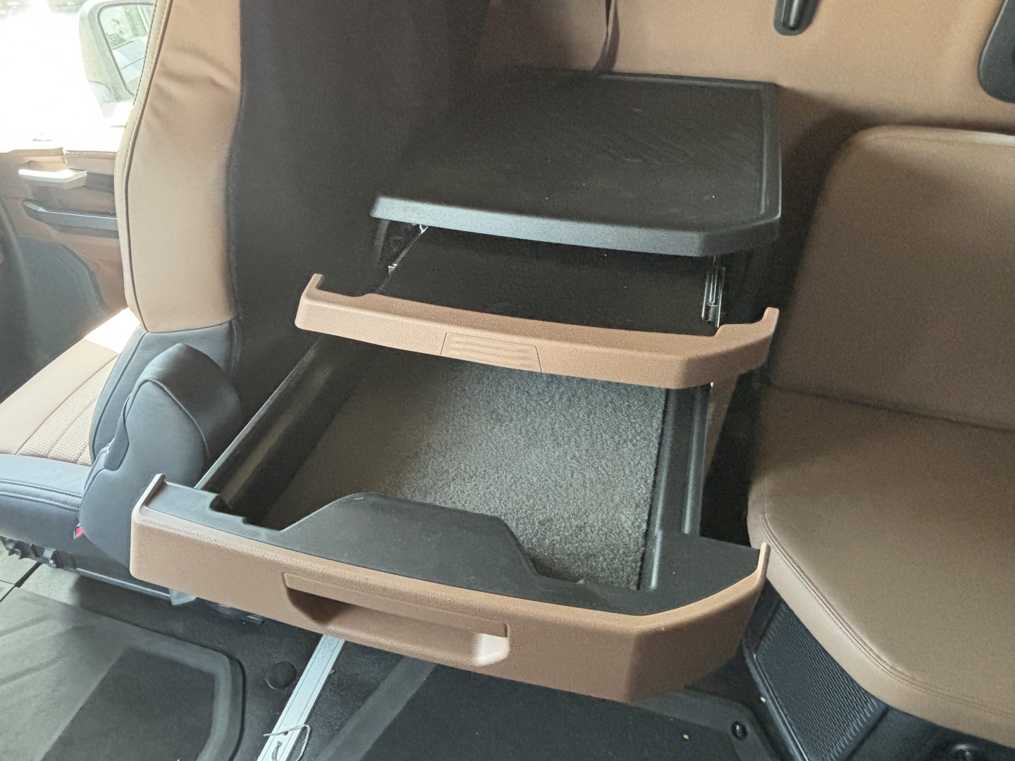 Mack PR64T76H cab interior showing open overhead storage compartments with beige trim in the back seat area.