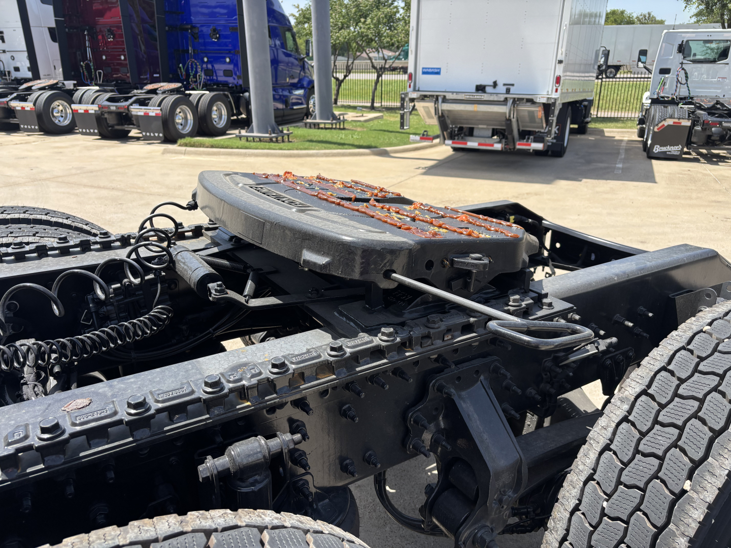 Truck chassis with fifth wheel and engine bay visible; shows Mack PR64T76H cabover? No, it's a tractor chassis with spare components.
