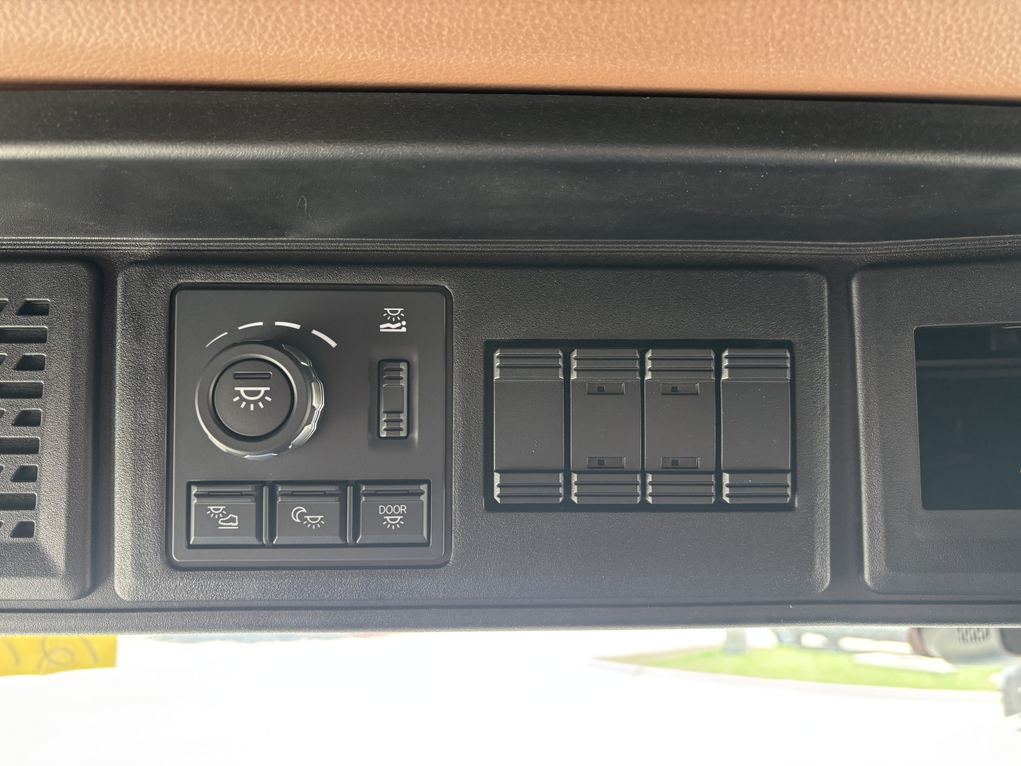 Dashboard control panel with headlight and gauge controls visible in a Mack PR64T76H truck interior.