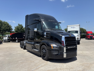 Mack PR64T76H tractor-trailer cab in black, front three-quarter view, showing Mack grille and side mirrors.