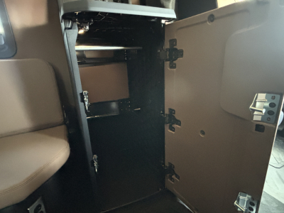 Interior cupola cabinet open showing storage compartments and hinges in a Mack PR64T76H truck cab