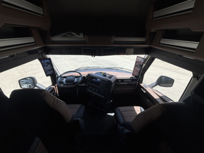 Mack PR64T76H truck cockpit interior showing dashboard, steering wheel, and overhead storage compartments.