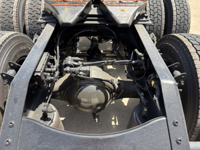 Rear axle view of 2027 Mack PR64T76H and chassis showing differential, suspension links, and dual rear wheels