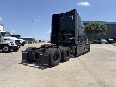 Truck cab and dual rear axles of a new 2027 Mack PR64T76H conventional sleeper tractor, rear view showing fifth-wheel area and dual tires.
