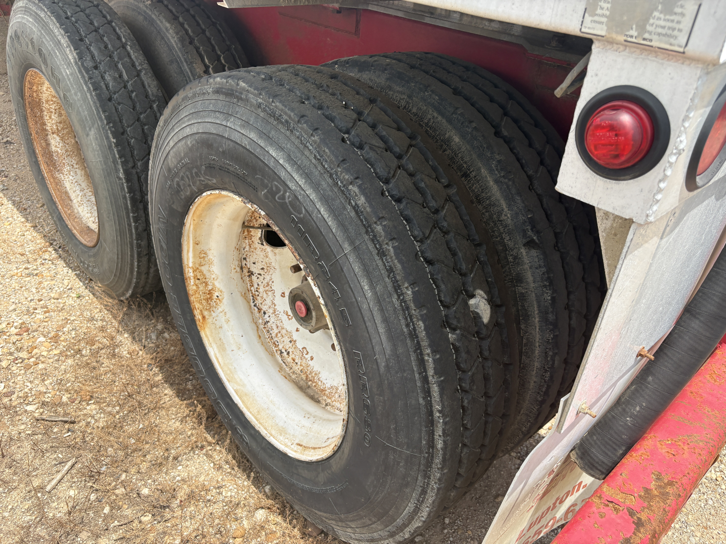 Dual rear tires of a 2012 Dragon 150BBL Vacuum trailer showing wheel rims and red rear light.