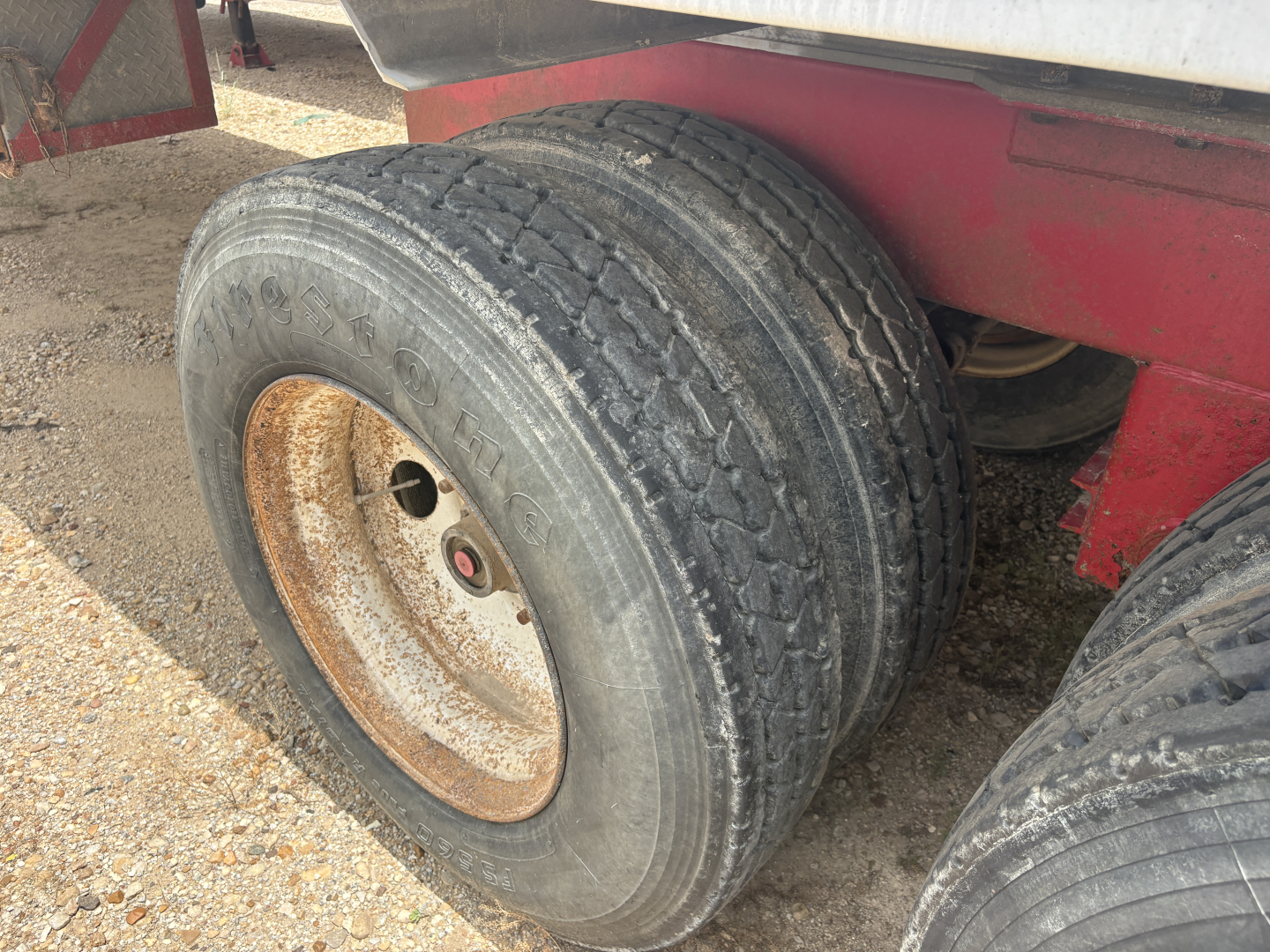 Dual rear wheels of a Dragon 150BBL vacuum trailer showing weathered tires and rusty rims.