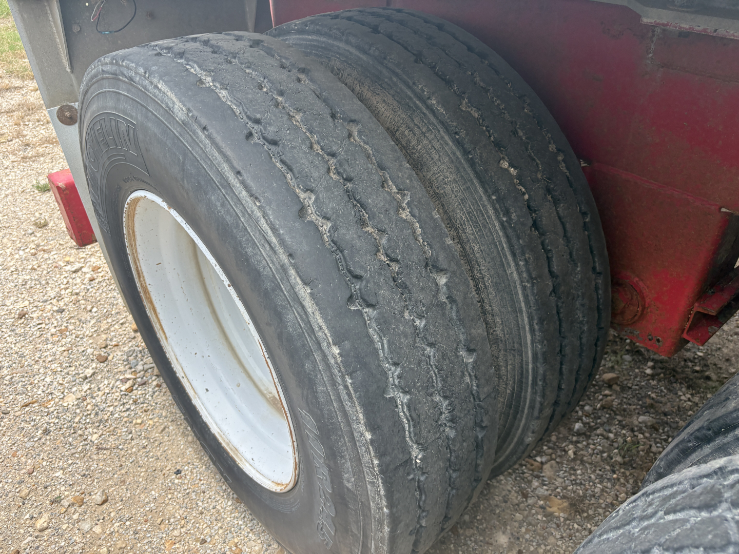 Wheel end of a 2012 Dragon vacuum trailer showing dual tires and white rim.
