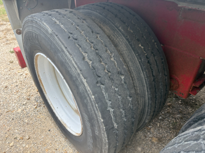 Wheel end of a 2012 Dragon vacuum trailer showing dual tires and white rim.