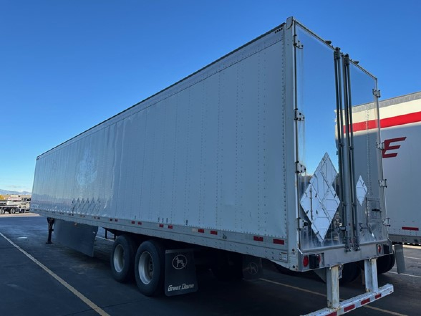 Great Dane trailer showing side and rear with dual rear doors and reflective diamonds; white aluminum exterior; three axles; stock number 708794.