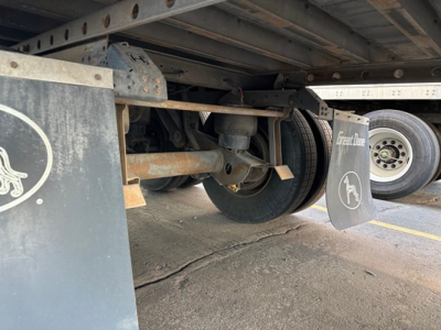 Trailer undercarriage showing wheel, suspension, and mud flaps with Great Dane branding.