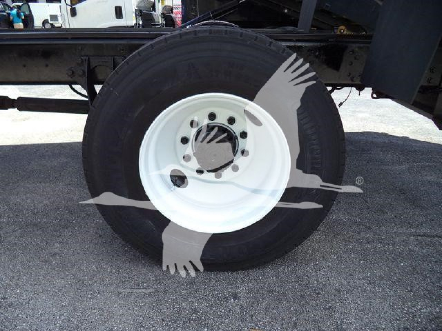 Wheel and tire assembly of a 2020 International MV truck showing white steel rim and black tire; part of chassis and frame visible in background.