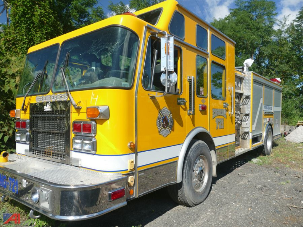 Yellow Spartan Gladiator fire truck with Cab SFD, side view showing front grille, large wheel arches, and hose compartments.