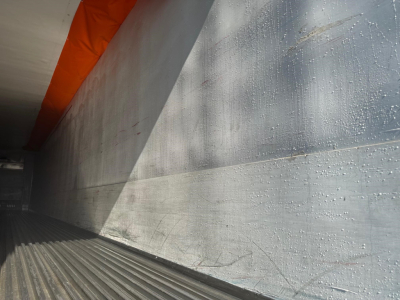 Trailer interior side wall and floor of a 2015 Utility S-600 reefer trailer showing aluminum ribbed wall and floor with orange fusible quick-release liner edge.