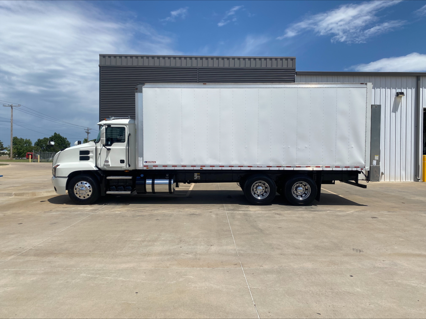 Box truck side view showing cargo area and Mack AN64 model trailer with white box and dual rear axles.