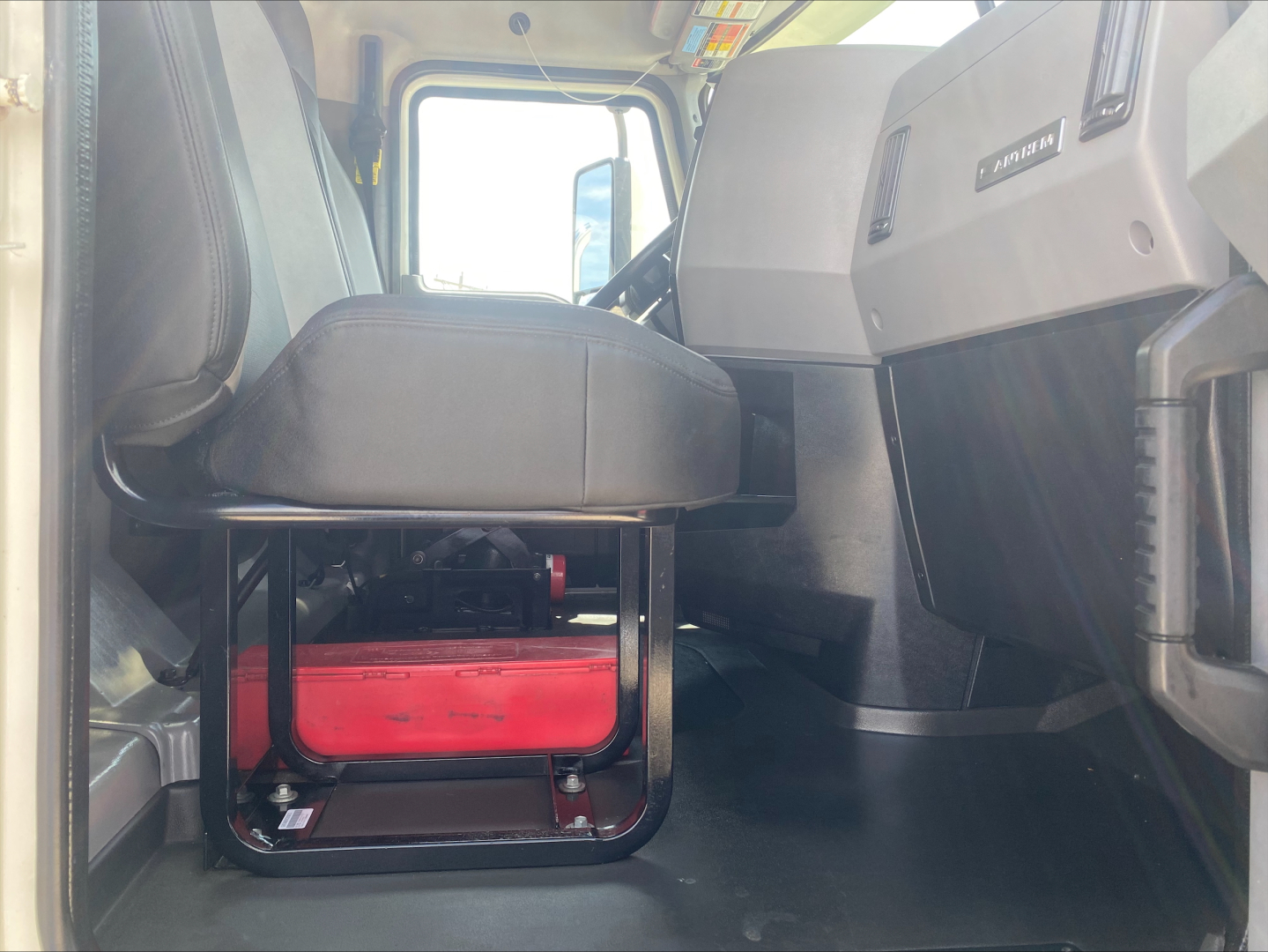 Cab interior of a 2019 Mack AN64 truck showing driver seat and dashboard view.