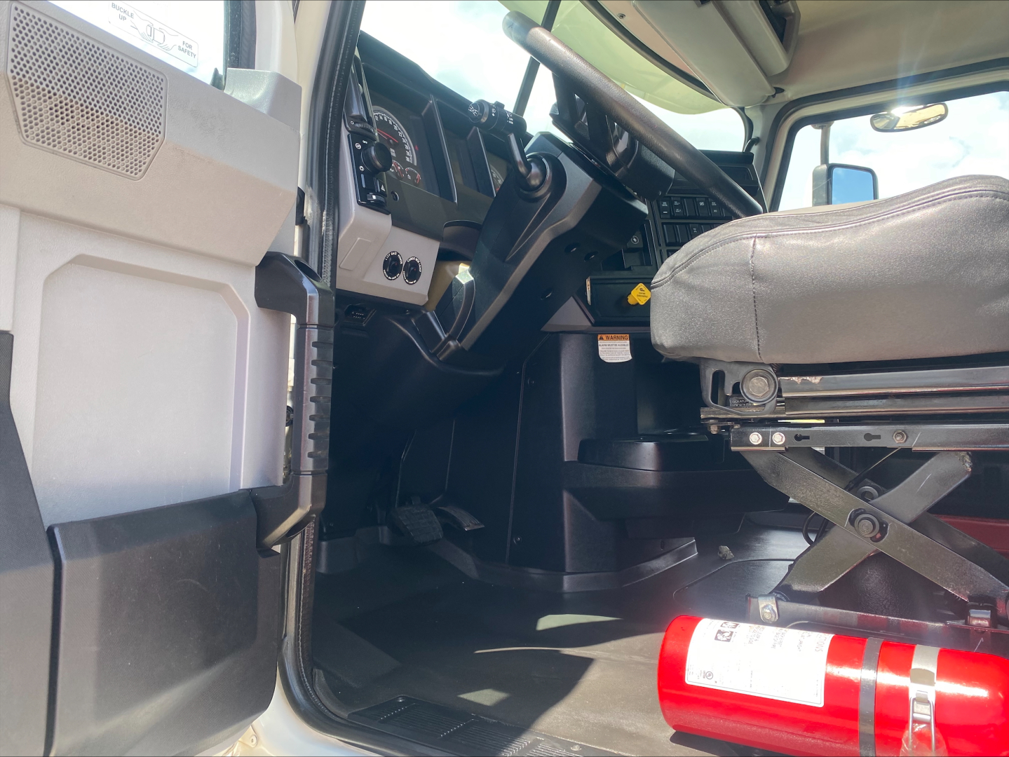 Mack AN64 truck cab interior showing driver seat and dashboard with steering wheel and control panels.