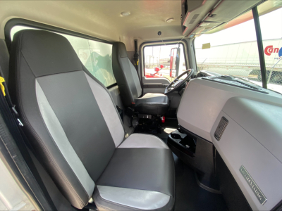 Truck cab interior showing two front seats, steering wheel, and dashboard of a 2019 Mack AN64 with light gray and dark gray seat upholstery.
