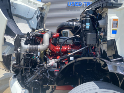 Mack AN64 engine bay showing red engine block, intake turbo, hoses, and various components in truck.