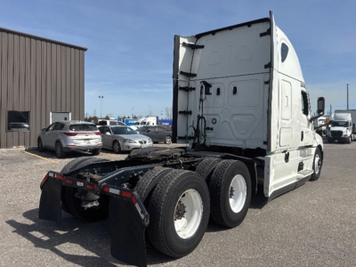Truck cab and chassis of a 2022 Freightliner Cascadia126 with sleeper, side view showing rear axles and fifth wheel area, white exterior, stock number 549444.