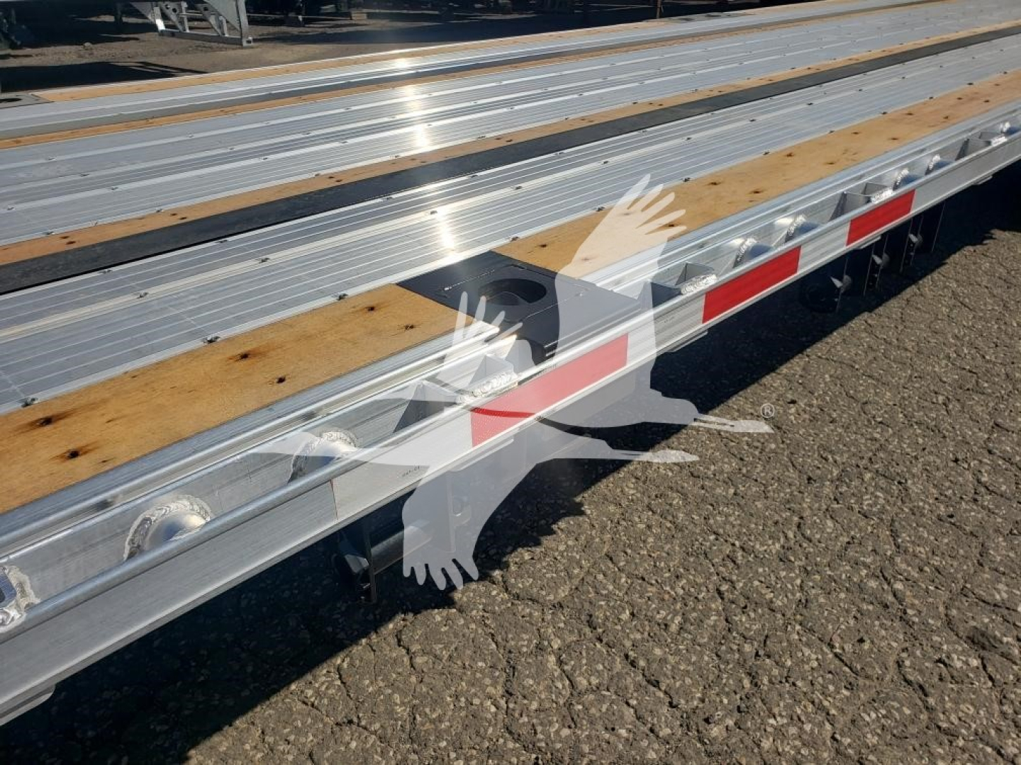 Wabash Combo Low Pro 17.5 trailer side view showing aluminum deck with wooden planks, reflective red/white side marker panels, and wheel hubs.