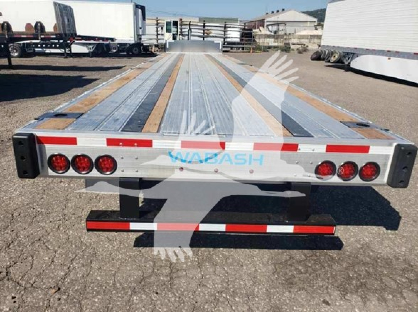 Trailer rear view showing Wabash logo and 6 taillights, drop deck low pro 17.5 truck trailer with reflective red-white strips.
