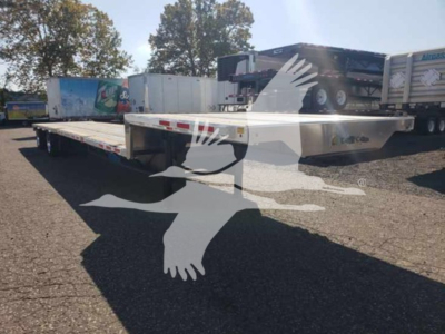 Trailer shown from side view on lot with drop deck, low pro 17.5 model, white with metal surface.