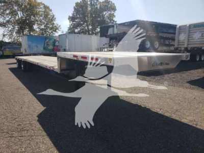 Trailer with low pro drop deck showing flatbed surface and tandem axles; no legible labels visible in this view.