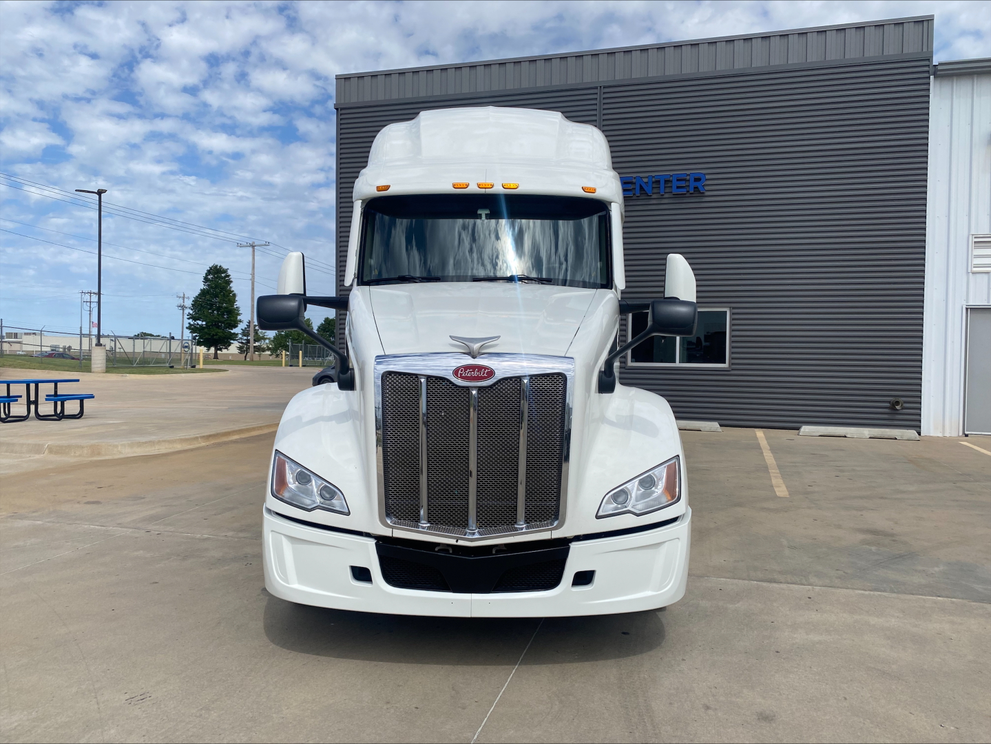 Peterbilt 579 truck front view in white with prominent grille and cab, headlights, and side mirrors.