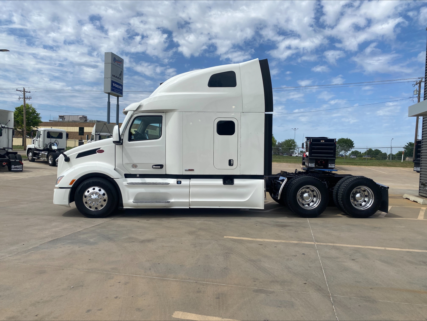Peterbilt 579 semi truck side view showing tractor with sleeper cab and dual rear axles in a lot.