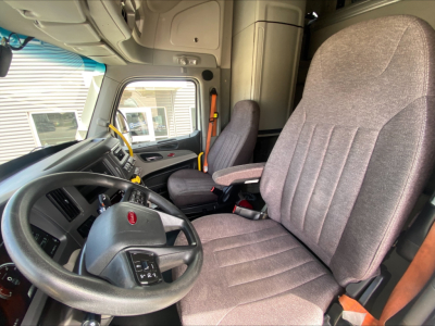 Semi truck cab interior showing steering wheel, driver's seat, and dashboard from a Peterbilt 579.