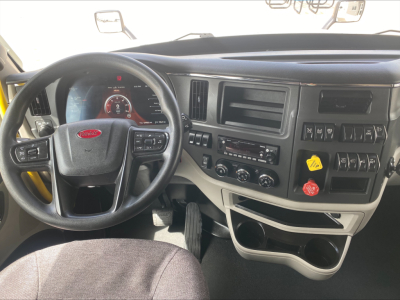 Peterbilt 579 truck dashboard and driver seat view with steering wheel and console, interior controls visible.