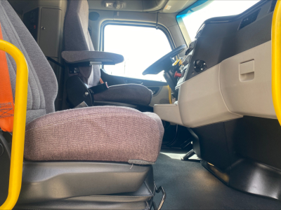 Peterbilt 579 truck interior driver seat and dashboard viewed from doorway showing steering wheel and console area.