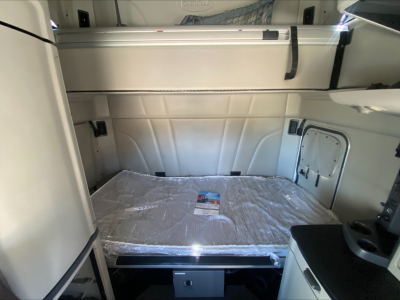 Peterbilt 579 sleeper cab interior cargo area with storage compartments and covered bed platform visible