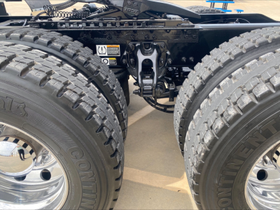Peterbilt 579 truck rear view showing tandem axle with dual large off-road tires and front frame components.