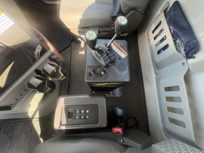 Cab interior of a Volvo VHD64B300 tracks with dual joysticks and control panel showing gear levers and dashboard switches.